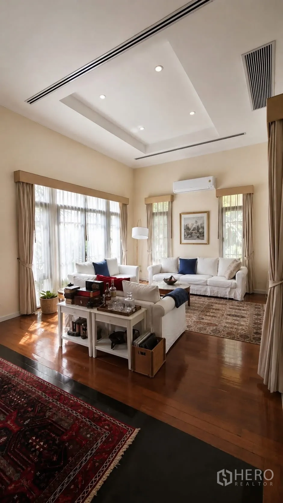 Detached House for rent in Watthana, Bangkok - Living room with high ceilings, white sofas and large curtains.