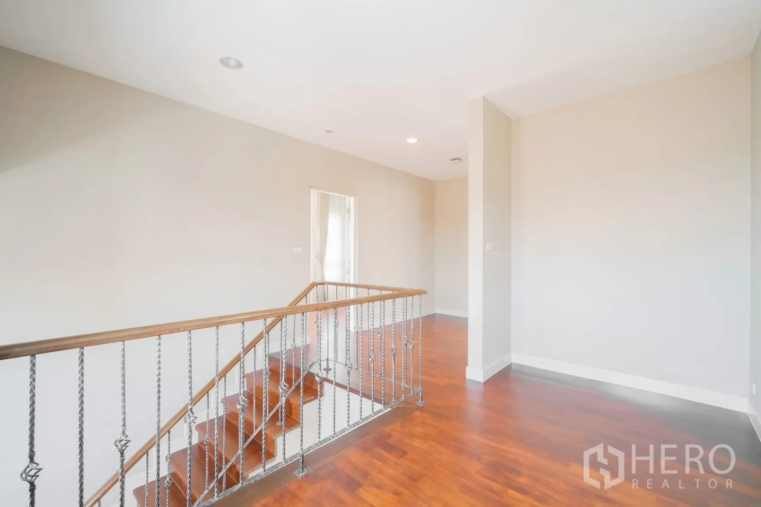 Detached House for rent or sale in Saphan Sung, Bangkok - Upper landing with wooden stairs and metal balustrade.