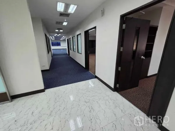 Office Space for rent in Khlong Toei, Bangkok - Bright corridor with tiled foyer, blue carpet and multiple private office doors.
