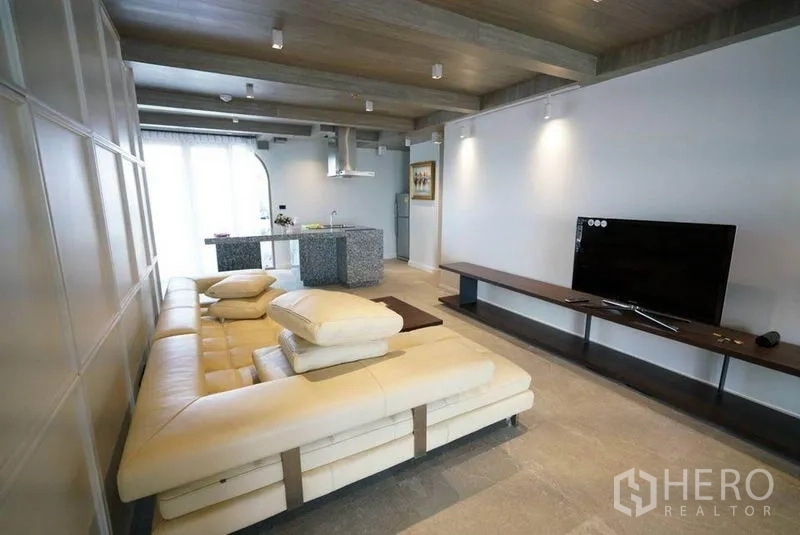 คอนโด ให้เช่าหรือขายในBang Na, Bangkok - พื้นที่นั่งเล่นโอเพนแพลน โซฟาตัวแอล ชั้นวางทีวี และครัวไอแลนด์หินแกรนิต