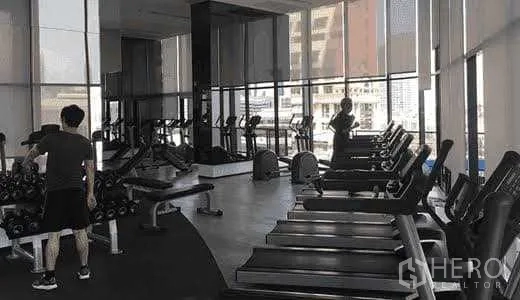 Condominium for sale in Bang Rak, Bangkok - Fitness center equipped with treadmills, free weights and city views.