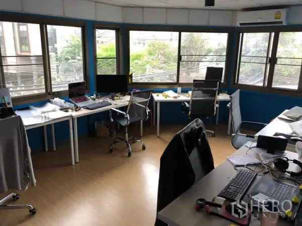 Shophouse for rent in Sathon, Bangkok - Upper-floor office workspace with wraparound windows, desks and city outlooks.