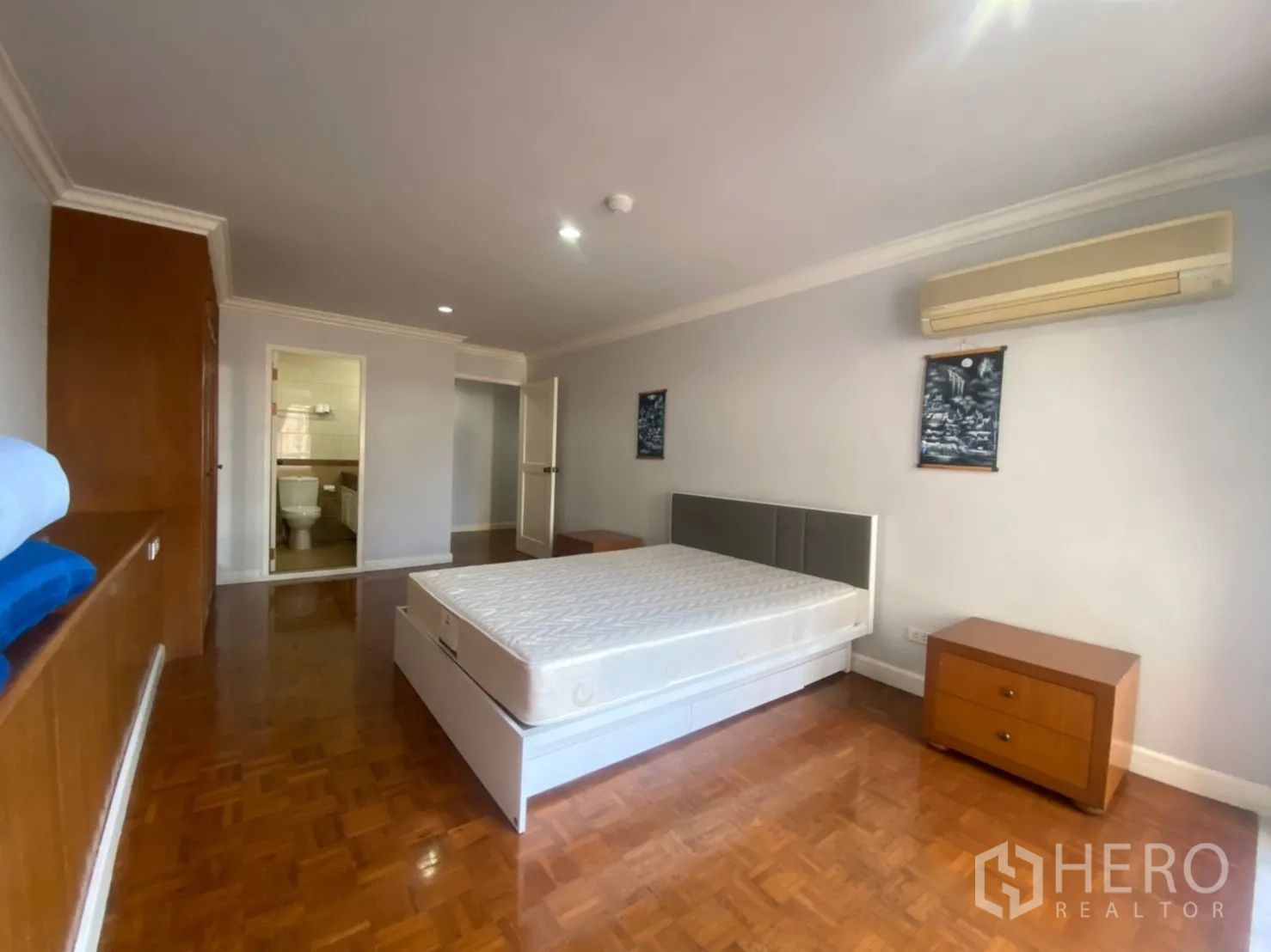 คอนโด ให้เช่าหรือขายในWatthana, Bangkok - ห้องนอนมีประตูเชื่อมเข้าห้องน้ำ แอร์ โต๊ะหัวเตียง และพื้นปาร์เกต์เงางาม