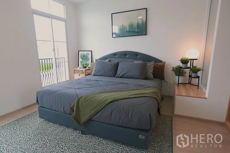 ทาวน์เฮาส์ ให้เช่าในPrawet, Bangkok - ห้องนอนมาสเตอร์พร้อมประตูกระจกออกระเบียงและต้นไม้ตกแต่ง