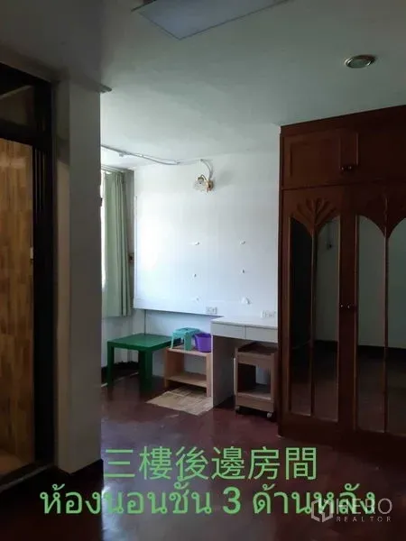 Townhouse for rent in Watthana, Bangkok - Bedroom with built‑in wooden wardrobe, small desk and curtained window.