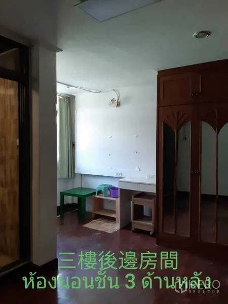 Townhouse for rent in Watthana, Bangkok - Bedroom with built‑in wooden wardrobe, small desk and curtained window.