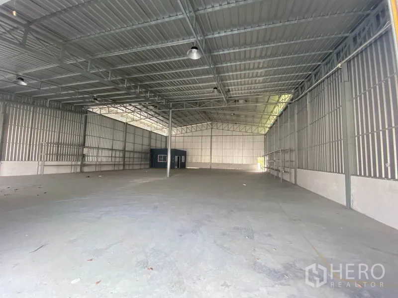 货栈 出租在Prawet, Bangkok - 仓库内部无柱空间，金属墙体、屋顶照明与大片混凝土地面。