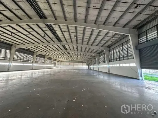 工厂 出租在Khlong Luang, Pathum Thani - 宽阔仓储生产区，高钢结构屋架，侧墙百叶通风，混凝土地面平整。