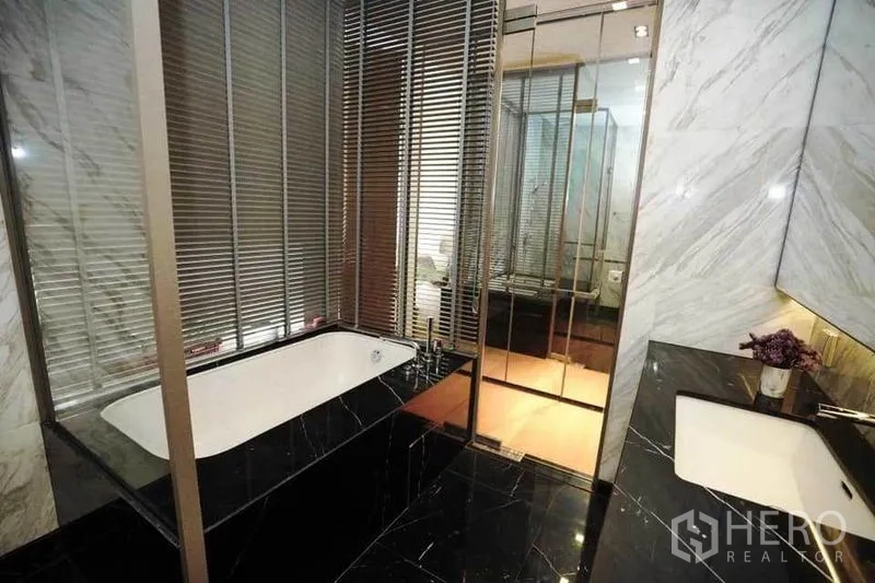 公寓 出租在Bang Rak, Bangkok - 浴缸区带百叶与双台盆的现代大理石浴室。