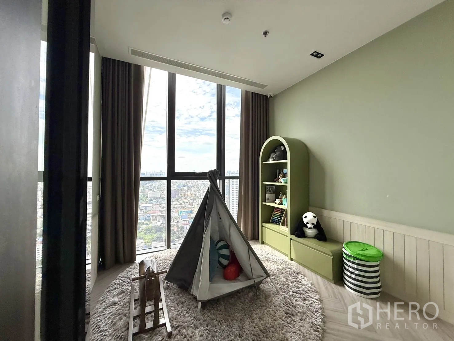 Condominium for sale in Chatuchak, Bangkok - Children’s playroom with teepee tent and toy shelves facing city views.