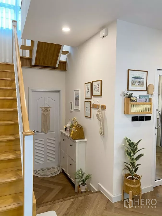 独立式住宅 出售在Sai Mai, Bangkok - 入口玄关，温润木楼梯与装饰柜。