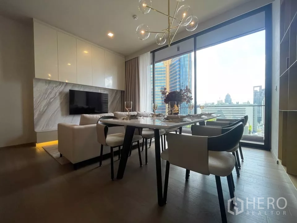 Condominium for rent in Watthana, Bangkok - Spacious dining zone with modern chandelier and panoramic windows facing the city.