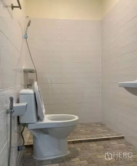 Home Office for rent in Sathon, Bangkok - Bathroom with a raised shower zone, handheld shower, and toilet.