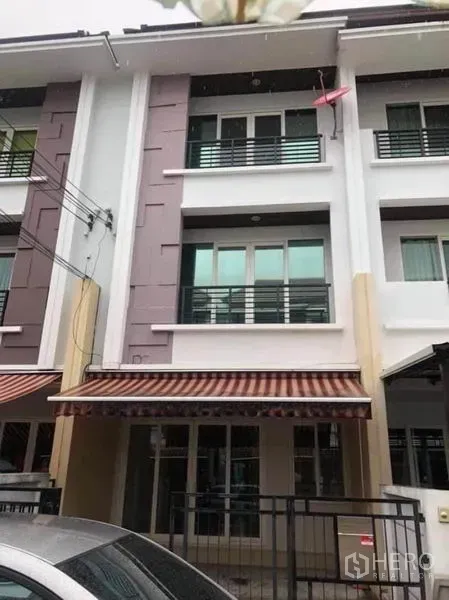 ทาวน์เฮาส์ ให้เช่าในWang Thonglang, Bangkok - ทาวน์เฮ้าส์ 3 ชั้นในเขตวังทองหลาง กรุงเทพฯ ด้านหน้า มีระเบียง กันสาดลายทาง และที่จอดรถพร้อมรั้ว