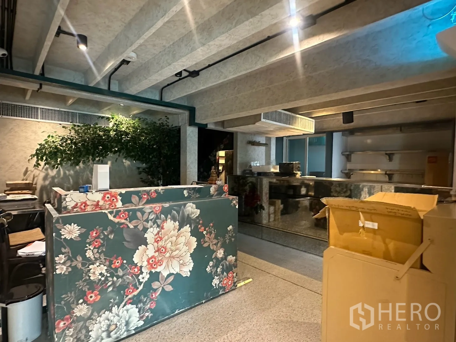 Detached House for rent in Watthana, Bangkok - Reception counter with floral panels beside a reflective bar.