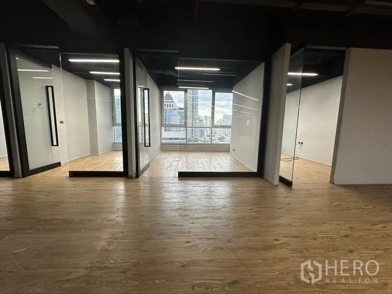 Office Space for rent in Bang Rak, Bangkok - Glass-front private rooms facing the Bangkok skyline within a modern office.