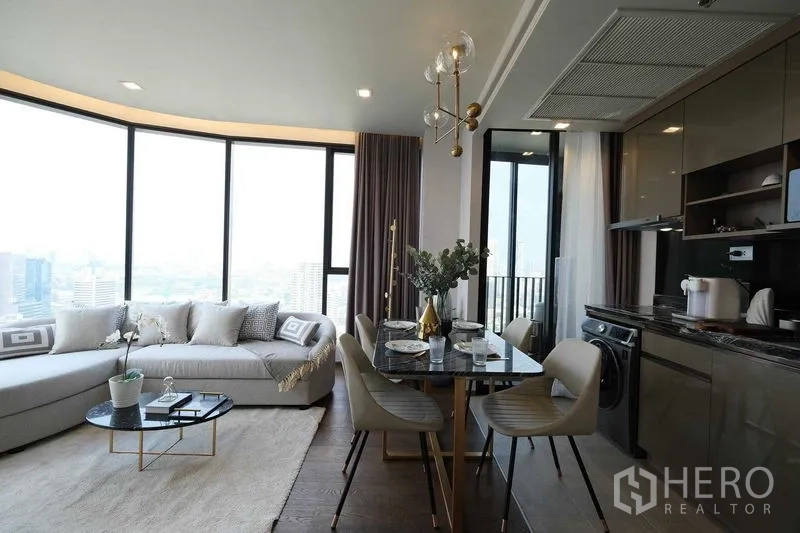 คอนโด ให้เช่าในKhlong Toei, Bangkok - มุมห้องนั่งเล่น–ทานอาหาร หน้าต่างพาโนรามา โซฟาโค้ง และครัวทันสมัย