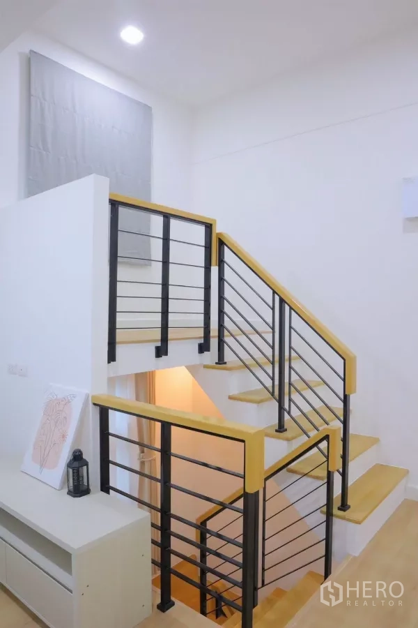 Detached House for rent in Bang Phli, Samut Prakan - Modern staircase with black metal balustrade and wood treads.