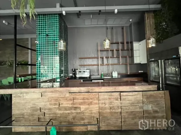 零售空间 出租 - 木饰面吧台，绿色瓷砖立柱、层架与咖啡机。