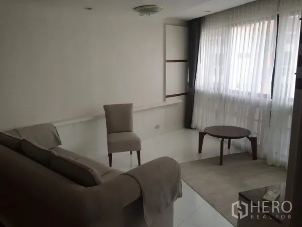 คอนโด ให้เช่าในKhlong Toei, Bangkok - มุมพักผ่อนสว่าง โซฟา เก้าอี้ และโต๊ะกลาง ข้างหน้าต่างบานใหญ่ ในคอนโด President Park