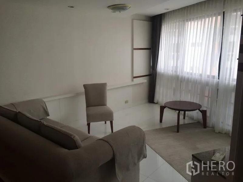 คอนโด ให้เช่าในKhlong Toei, Bangkok - มุมพักผ่อนสว่าง โซฟา เก้าอี้ และโต๊ะกลาง ข้างหน้าต่างบานใหญ่ ในคอนโด President Park