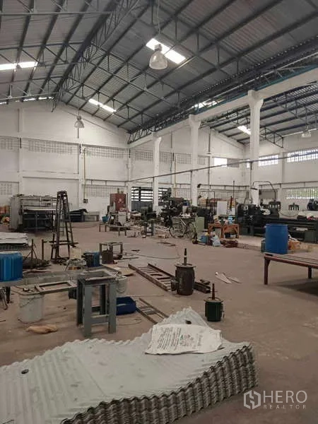 Warehouse for rent or sale in Nong Suea, Pathum Thani - Wide factory floor with skylights, machines and open work zones.