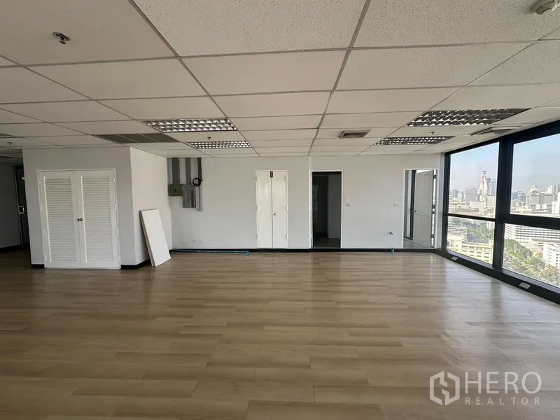 办公空间 出租在Bang Rak, Bangkok - 宽敞办公室内景，落地大窗享城市景观，多扇门通往会议室。