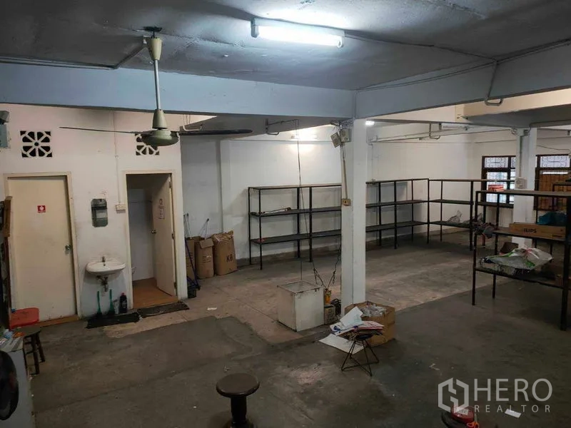 อาคารพาณิชย์ ให้เช่าในWatthana, Bangkok - โซนสต็อกสินค้าด้านหลัง พื้นคอนกรีต พัดลมเพดาน อ่างล้างมือ และชั้นเหล็ก