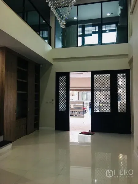 ทาวน์เฮาส์ ให้เช่าในYan Nawa, Bangkok - โถงทางเข้าเพดานสูง ประตูลายตะแกรงสีดำ ผนังกระจกชั้นลอย และตู้บิลท์อิน