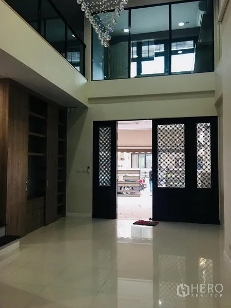 ทาวน์เฮาส์ ให้เช่าในYan Nawa, Bangkok - โถงทางเข้าเพดานสูง ประตูลายตะแกรงสีดำ ผนังกระจกชั้นลอย และตู้บิลท์อิน