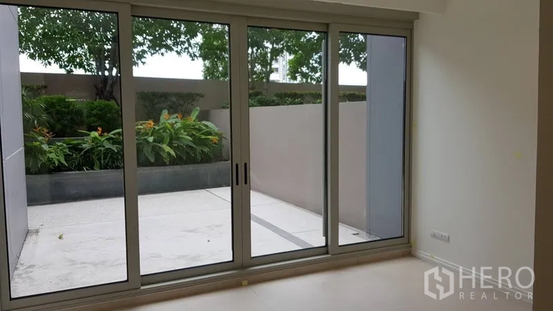 คอนโด ขายในKhlong San, Bangkok - ห้องนอนมีประตูกระจกสูง มองเห็นสวนและกระบะต้นไม้