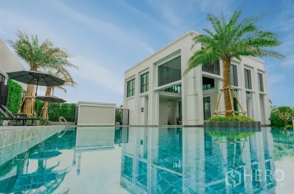 ทาวน์เฮาส์ ให้เช่าในChatuchak, Bangkok - สระน้ำสีฟ้าถัดจากคลับเฮาส์สีขาว รายล้อมด้วยต้นปาล์ม