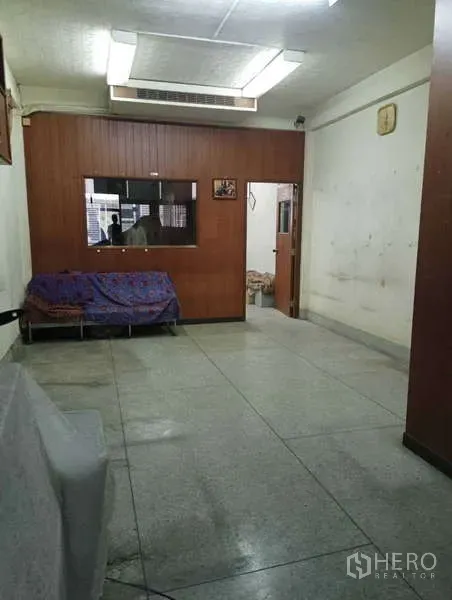 อาคารพาณิชย์ ให้เช่าในKhlong Toei, Bangkok - ห้องเรียบง่าย ผนังไม้กั้น ไฟนีออน และโซฟาคลุมผ้า