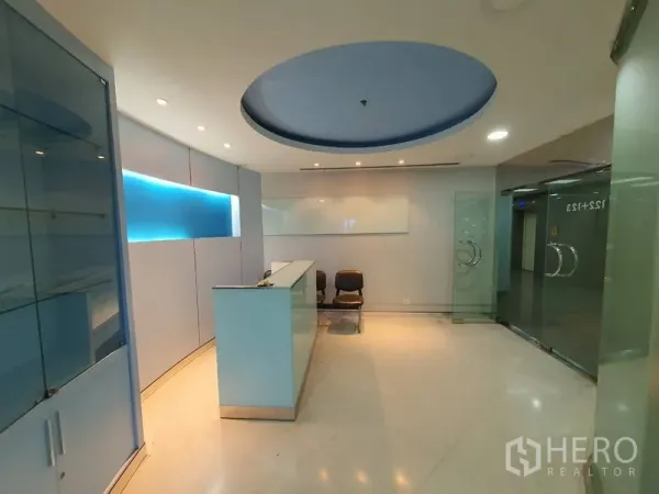 办公空间 出租在Watthana, Bangkok - 现代接待区，圆形吊顶、玻璃门与前台柜台。