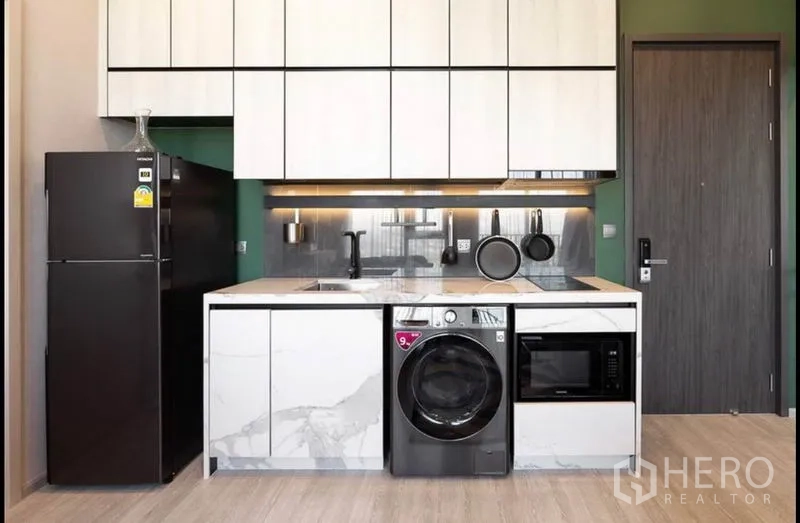 公寓 出租在Phra Khanong, Bangkok - 时尚一字型厨房，岩纹柜体，配冰箱、微波炉与洗衣机。