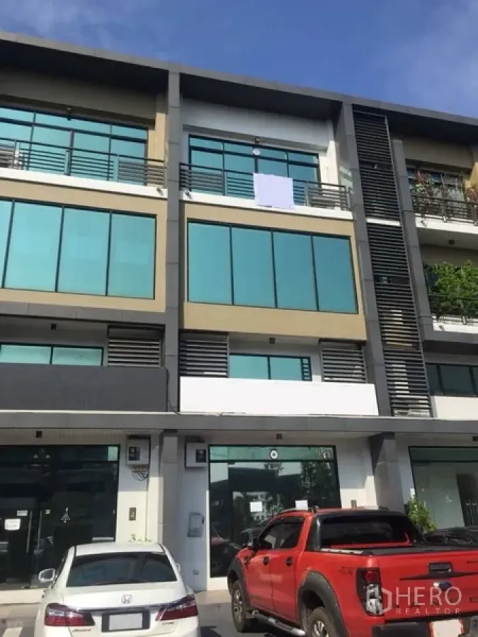Home Office for rent or sale in Prawet, Bangkok - Modern multi-storey home office at H-Cape in Prawet with large tinted glass facade and parking in front.