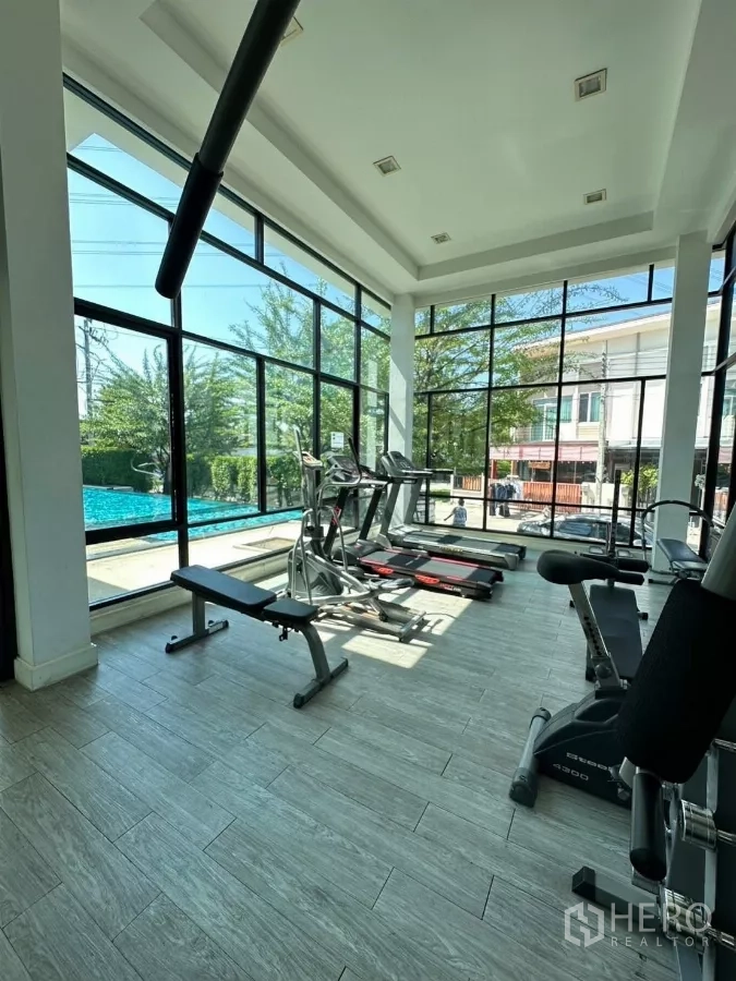 ทาวน์เฮาส์ ให้เช่าในBang Phli, Samut Prakan - ห้องฟิตเนสกระจกใส มองเห็นสระว่ายน้ำ พร้อมอุปกรณ์คาร์ดิโอและเวท