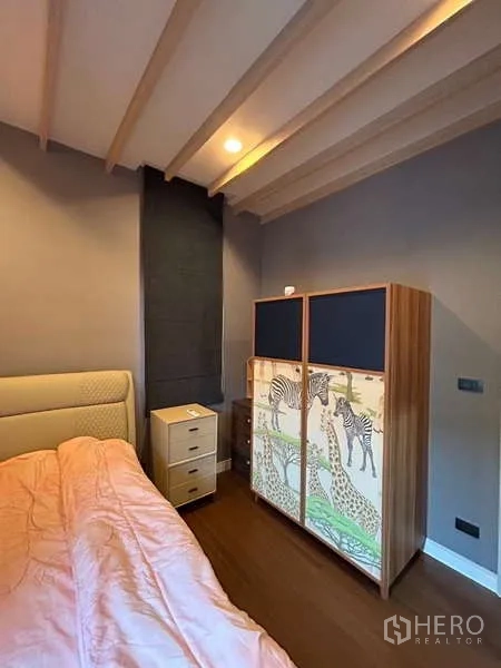 Detached House for rent in Bang Kapi, Bangkok - Secondary bedroom with upholstered bed, exposed ceiling beams and patterned cabinet.