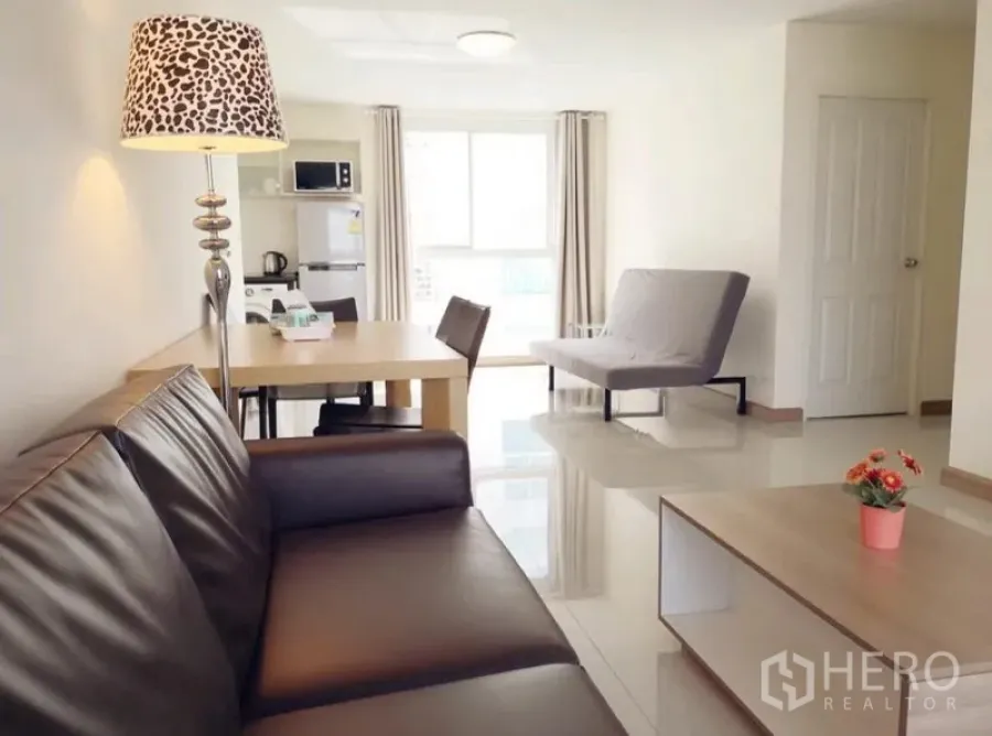 Condominium for rent in Phra Khanong, Bangkok - Spacious lounge facing the dining area and kitchenette with fridge and microwave, glossy tile floors and ample natural light.