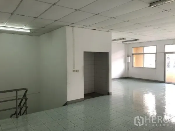 Factory for rent in Pathum Thani - Open-plan office level with stairwell access and window to balcony.