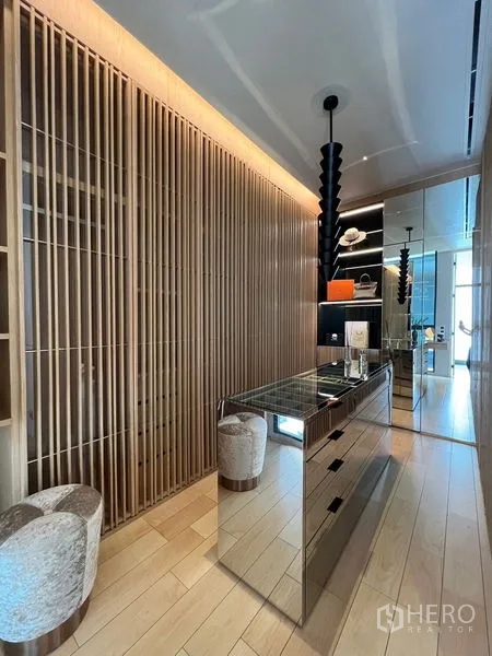 Home Office for sale in Prawet, Bangkok - Walk-in dressing room with mirrored island, wood-slat wall, and display shelving.