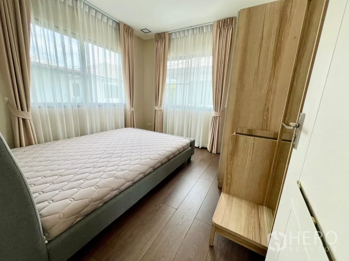 Detached House for rent or sale in Bang Phli, Samut Prakan - Corner bedroom with wraparound windows and soft beige curtains.