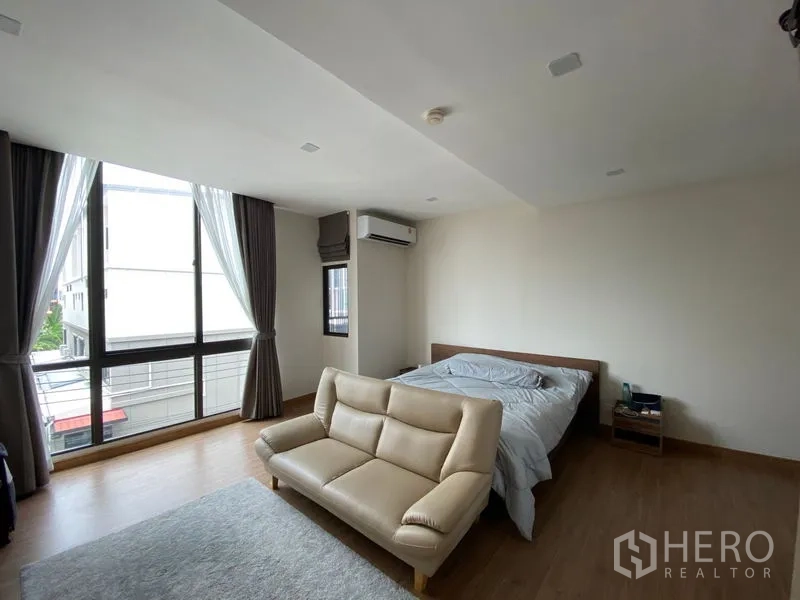 ทาวน์เฮาส์ ให้เช่าในSuan Luang, Bangkok - ห้องนอนมาสเตอร์กว้าง หน้าต่างมุมกว้าง แอร์ และโซฟา