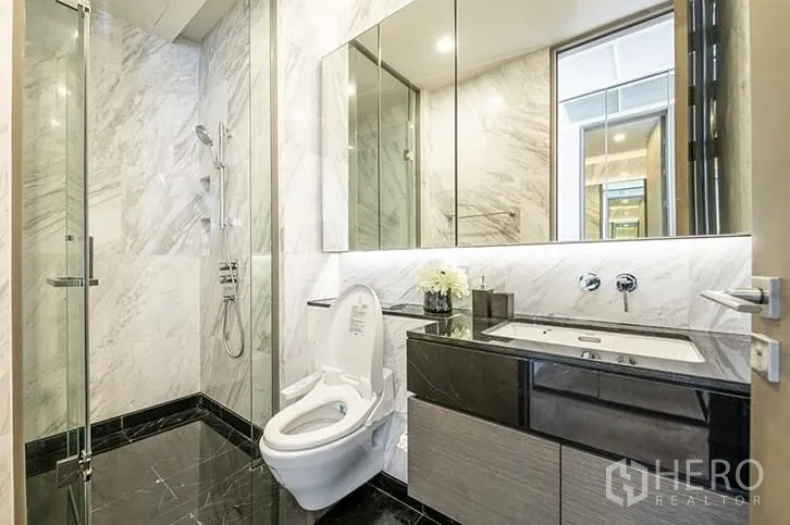 คอนโด ให้เช่าในBang Rak, Bangkok - ห้องน้ำโมเดิร์น ผนังหินอ่อน ฝักบัวกระจก และอ่างล้างหน้า