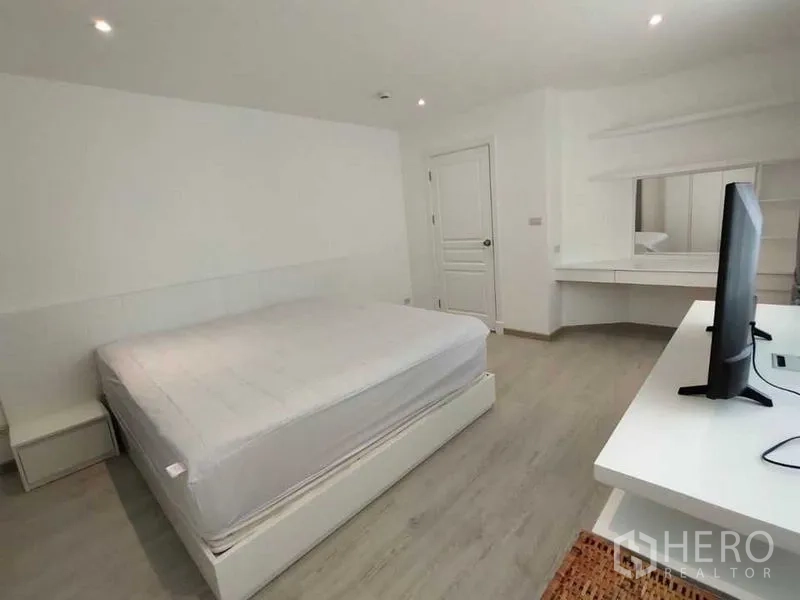 คอนโด ให้เช่าในBang Rak, Bangkok - ห้องนอนรองพร้อมเตียง ทีวีบนโต๊ะ และโต๊ะเครื่องแป้งบิวท์อิน โทนสีเรียบ