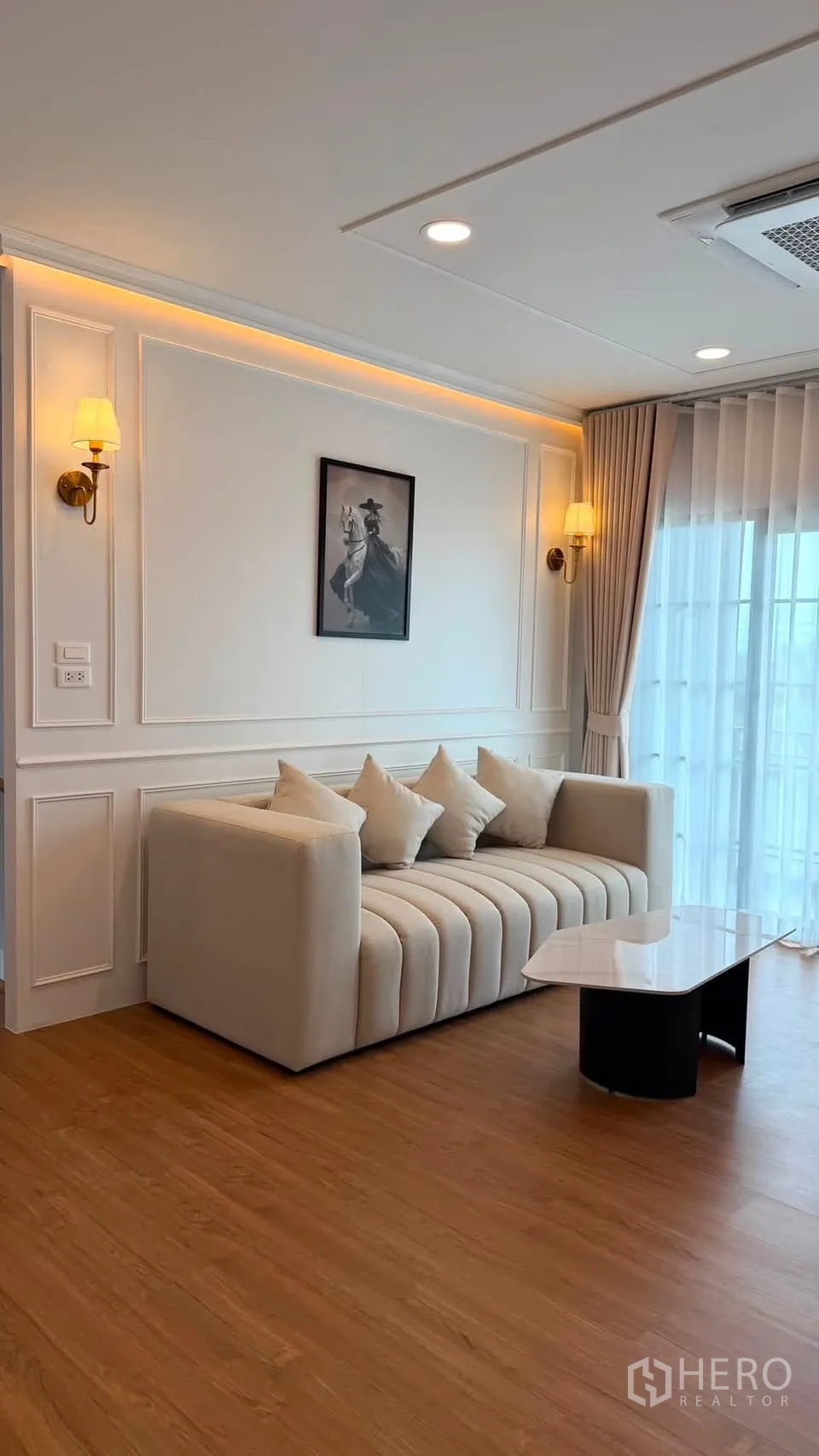 บ้านเดี่ยว for rent or sale in Bang Phli, Samut Prakan - มุมมองอีกด้านของห้องนั่งเล่น แสดงโซฟา ไฟซ่อน และผ้าม่านสูงจรดเพดาน