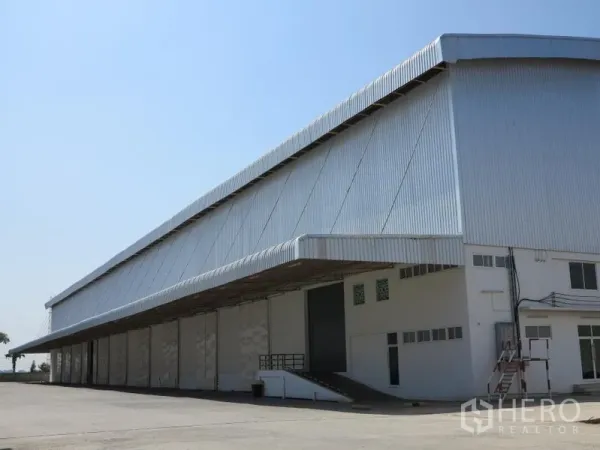 货栈 出租在Lopburi - 大型金属外墙仓库，设有带顶装卸区和坡道，晴空下