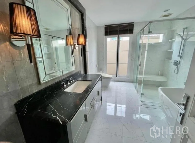 Detached House for rent in Bang Phli, Samut Prakan - Elegant bathroom with black stone vanity, glass shower and soaking tub.