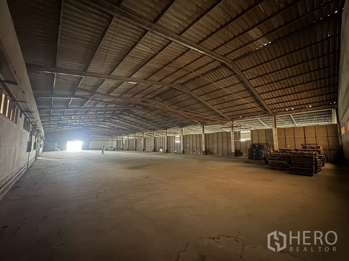 Warehouse for rent in Khlong Toei, Bangkok - Wide‑span warehouse hall with stacked pallets and side openings.