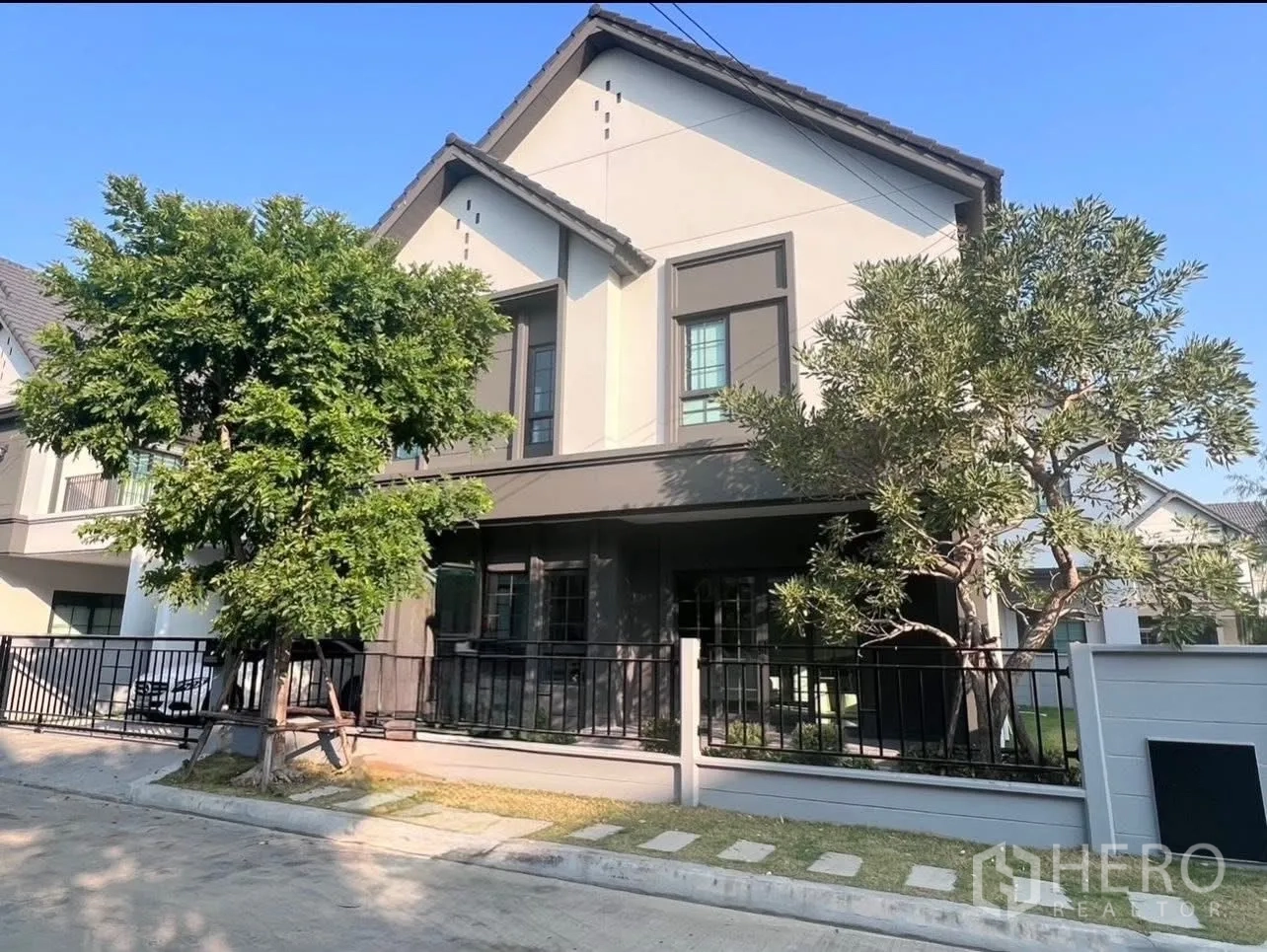 Detached House for rent in Bang Phli, Samut Prakan - Modern two-storey detached house exterior with pitched roof, fenced yard and mature trees.